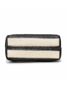 Detail view of the hand-woven black and white striped texture on a crossbody tote bag