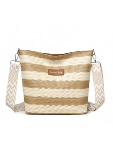 Detail of bohemian striped woven tote bag featuring a wide patterned strap and leather logo patch