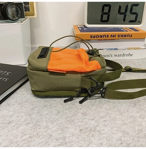 Detail of olive nylon crossbody bag with orange mesh pocket and drawstring closure