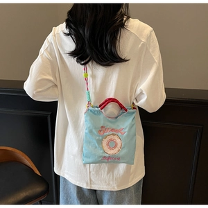 Vue arrière du mannequin portant le sac en tissu bleu clair avec broderie donut