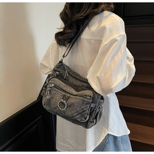 Détail du sac bandoulière en denim délavé gris foncé avec multi-poches et anneau