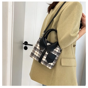 Detail view of plaid crossbody bag featuring a creative shirt collar design and buttons
