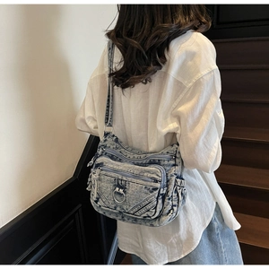Sac bandoulière rétro en denim délavé bleu avec plusieurs poches zippées et anneau métallique