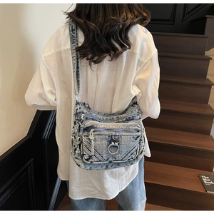 Vue arrière du modèle portant un sac bandoulière vintage en jean bleu à poches multiples