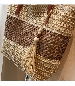 Detail der Strohtasche mit Kontrastgewebe und kreativem Quastenanhänger mit Holzperlen
