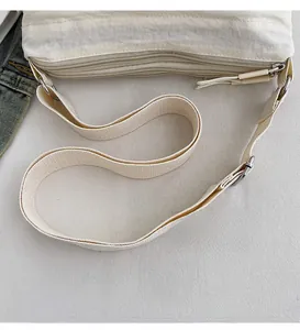 Detailed view of the three-layer zipper compartments and smooth shoulder strap of this beige bag