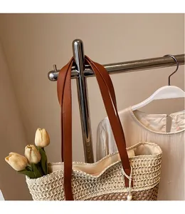 Detail der Stroh-Tragetasche mit Kontrastfarbe und braunem Ledergriff-Design