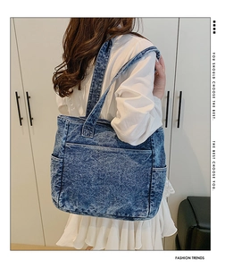 Detail of blue denim tote bag showing multiple pockets and washed fabric texture