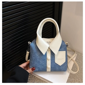 Detail van blauwe handtas met denim textuur en creatief ontwerp van overhemdkraag en knopen