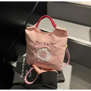 Détail sac en toile rose avec broderie Sweet, motif donut et poignées en corde tressée
