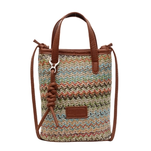 Colorful woven straw bucket bag with brown leather straps for summer beach holidays