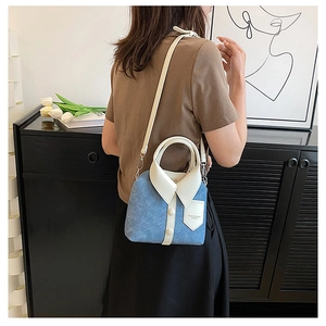 Detail van de creatieve blauwe denim crossbodytas in de vorm van een shirt gedragen door model