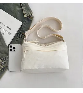 Detailed comparison of beige nylon crossbody bag capacity with a mobile phone and books