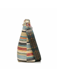 Detail of woven straw tote bag with colorful stripes and patterned bohemian strap