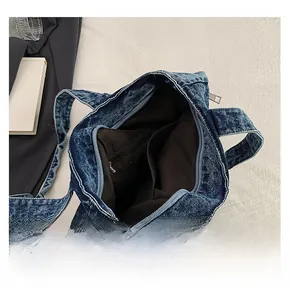 Detail view of the spacious denim tote interior featuring secure zippers and pockets