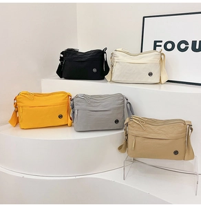 Detailed view of five colorful water-resistant nylon crossbody bags with multiple compartments