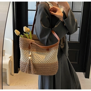 Detail der gewebten Stroh-Tote-Bag mit braunem Farbverlauf und Leder-Schultergurt-Elementen