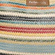 Close-up of zig-zag woven tote bag fabric with colorful stripes and leather label