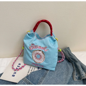 Détail du sac à cordon Sweet bleu clair avec poignées tressées rouges et broderie