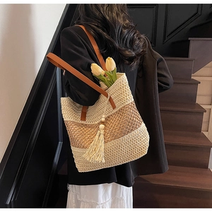 Detail der Stroh-Tote-Bag mit gewebter Textur, Fransanquaste und braunem Ledergriff