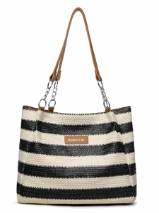 Detail of woven black and white striped tote bag with brown leather patch and chain handle