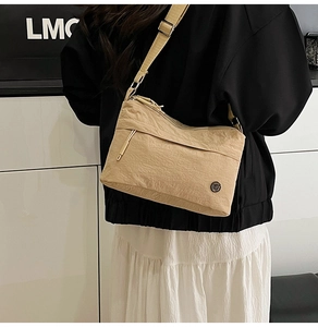Detailed shot of beige nylon crossbody bag with water-resistant fabric and wide strap