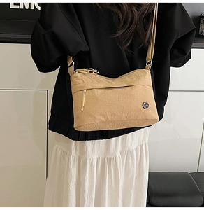 Detail of khaki nylon crossbody bag with pleated texture and adjustable wide strap