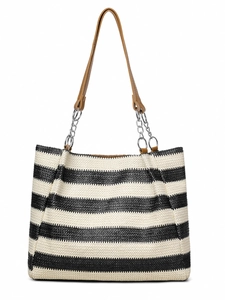 Detail of woven straw tote bag with black stripes and brown chain shoulder strap