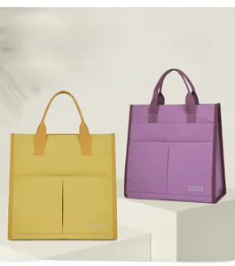 Detail of yellow and purple canvas tote bags with dual front pockets on display stand