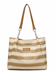 Close-up of woven straw tote bag featuring beige stripes and leather brand tag