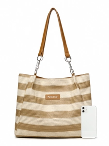 Detail of striped woven straw tote bag featuring a leather brand tag and chain strap