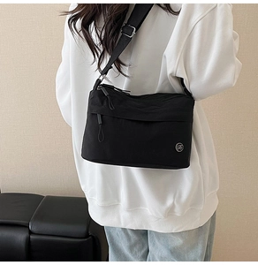 Detail of waterproof nylon crossbody bag with adjustable strap and metal logo accent