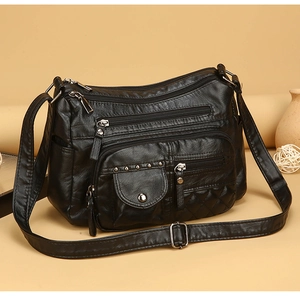 Détails d'un sac bandoulière noir à plusieurs poches avec matelassage et boucles argent