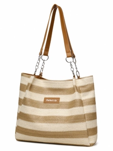 Detail of woven straw tote bag with striped texture and leather logo patch with chain strap