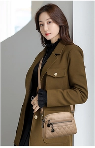 Detail of khaki leather crossbody bag with quilted pattern and multi-zipper compartments