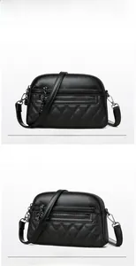 Macro detail of black quilted leather crossbody bag with gunmetal zippers and dual pockets