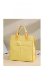 Detail of yellow canvas office tote bag featuring two front utility pockets for organization