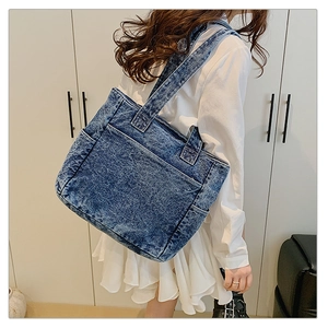 Blue washed denim tote bag with external pockets shown as casual style on model