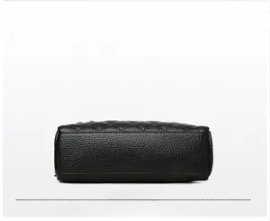 Detail view showing rectangular bottom and pebbled leather texture of the black shoulder bag