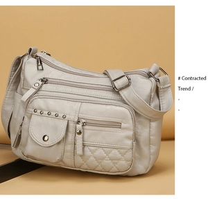 Détail du sac bandoulière blanc cassé avec poche rivetée et surpiqûres matelassées