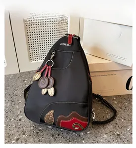 Detailed view of black waterproof nylon backpack with colorful patchwork and metal logo