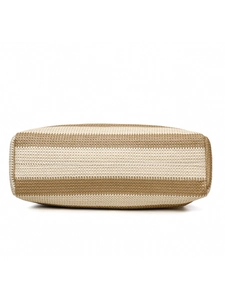 Detail view of woven straw tote bag bottom showing striped pattern and sturdy stitching