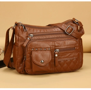 Détail d'un sac bandoulière en cuir PU marron avec fermetures éclair et surpiqûres