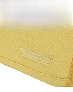 Macro shot of yellow canvas material with leather logo detail and fine stitching