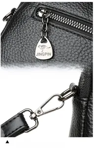 Detail of black lychee grain leather bag with silver metal zipper and shoulder strap hooks