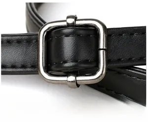 Detail of black leather shoulder bag strap with adjustable silver metal buckle