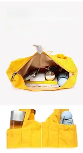 Close-up of large yellow canvas tote interior showing spacious storage and side pockets