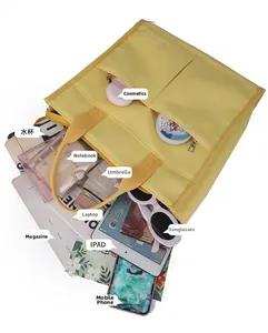 Detail view of yellow canvas tote bag featuring multiple pockets for 14-inch laptop storage