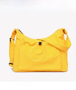 Detailed view of bright yellow canvas tote bag featuring external pocket and adjustable strap