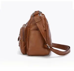 Vue latérale du sac à bandoulière en similicuir marron avec poches zippées et sangle